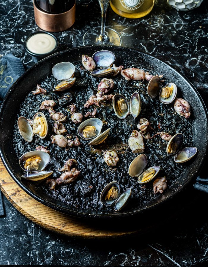 Paella arroz negro con chipirones y allioli   (mínimo 2 raciones, precio por ración).                                   | 28€